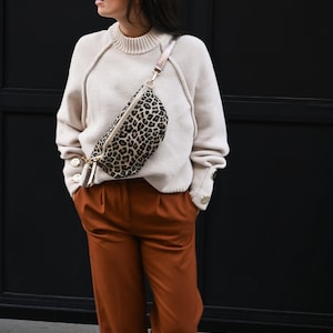 Riñonera con estampado de leopardo | tamaño mediano 24,5 x 18 x 8,5 cm | acabados con cremallera y clip en tono dorado, correa ajustable de piel rígida