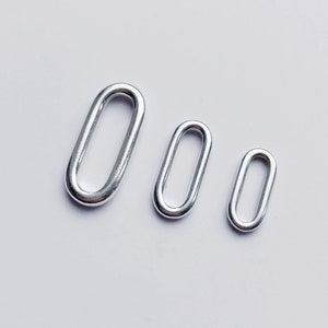 Peut inclure: Trois anneaux métalliques ovales de différentes tailles, de couleur argent.