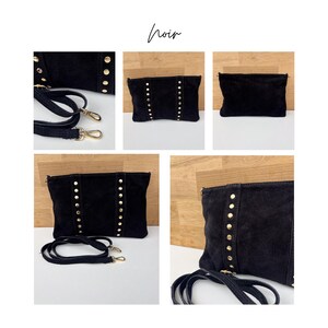 May include: A black suede clutch with gold-colored stud accents. The bag has a detachable strap and gold-colored hardware. The word "noir" is written in cursive at the top of the image.