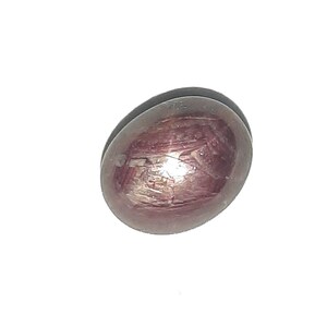 Può includere: Una pietra preziosa di rubino stella rossa a cabochon con una stella a sei punte.