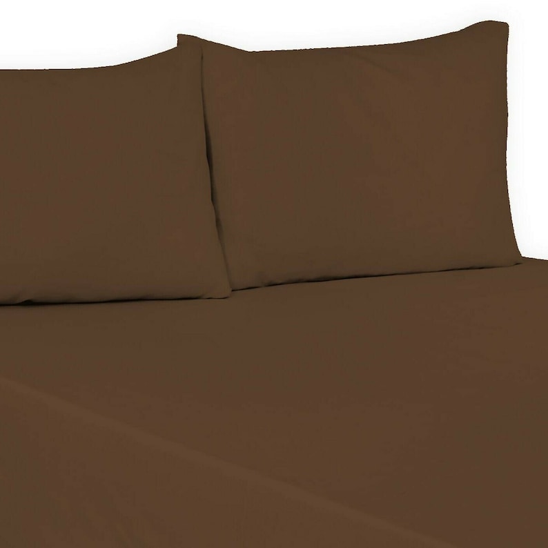 May include: Two brown pillowcases, one on top of the other, with a brown fitted sheet underneath.