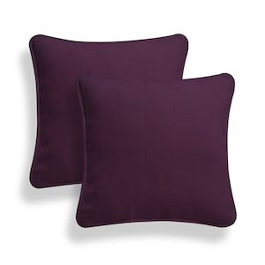 May include: Two purple square throw pillows with a subtle texture.