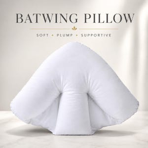 May include: A white batwing pillow with a distinct three-section design featuring a central support column and two side wings. The text BATWING PILLOW, SOFT, PLUMP, SUPPORTIVE is displayed above the pillow in a dark grey serif font.