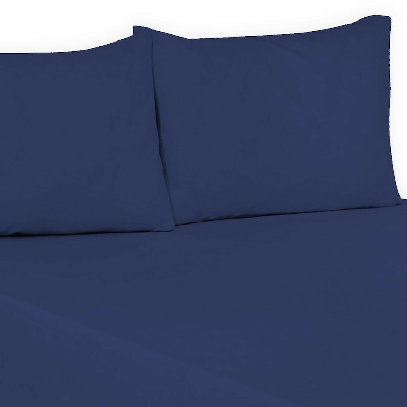 May include: Two navy blue pillowcases on a navy blue fitted sheet.