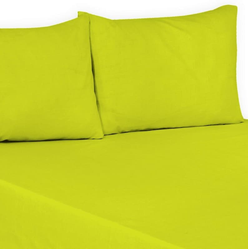 May include: A bright lime green bed sheet set with two matching pillowcases. The sheet set is made of a soft, comfortable fabric.