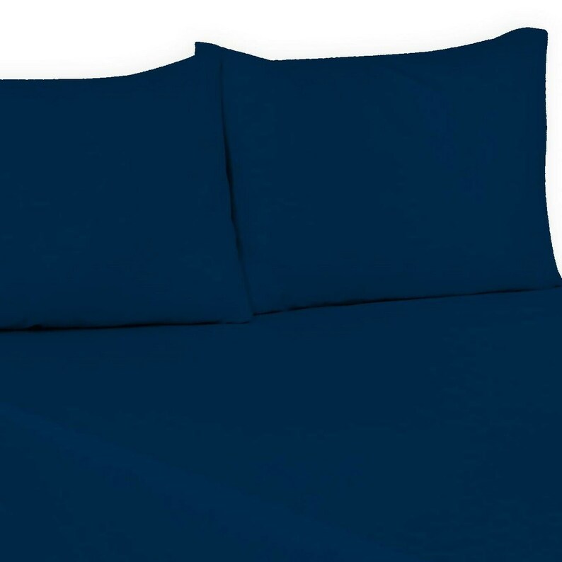 May include: Two dark blue pillowcases and a matching dark blue fitted sheet. The sheet is smooth and wrinkle-free.