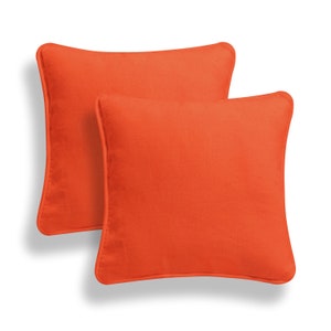 May include: Two orange square throw pillows with a subtle texture. The pillows are made of a soft, durable fabric and are perfect for adding a pop of color to any room.