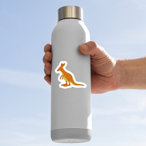 May include: A white water bottle with a kangaroo sticker on it. The kangaroo is orange and yellow.