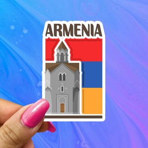 May include: A sticker with the word "ARMENIA" in bold, black letters. The sticker features a cartoon illustration of a church with a red, blue, and orange flag behind it.