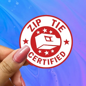 May include: A white circle sticker with red text and a red zip tie icon. The sticker says "Zip Tie Certified" with five red stars around the icon.