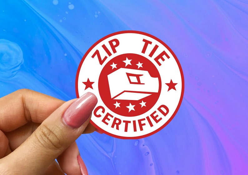 May include: A white circle sticker with red text and a red zip tie icon. The sticker says "Zip Tie Certified" with five red stars around the icon.