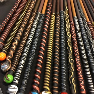 May include: A collection of decorative wands with various coloured and textured finishes. The wands have different coloured orbs at the end, including green, blue, red, white, and orange.