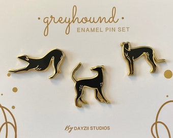 Pode incluir: Um conjunto de três pinos de esmalte dourado com silhuetas pretas de galgos em diferentes poses. Os pinos estão em um cartão branco com o texto "greyhound. ENAMEL PIN SET" e "by DAYZII STUDIOS".