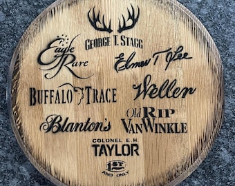 Op de afbeelding: Een houten vatenkop met verschillende bourbonmerken gegraveerd in zwarte letters, waaronder Eagle Rare, George T. Stagg, Elmer T. Lee, Buffalo Trace, Weller, Blanton's, Old Rip Van Winkle, Colonel E.H. Taylor en 1st and Only.