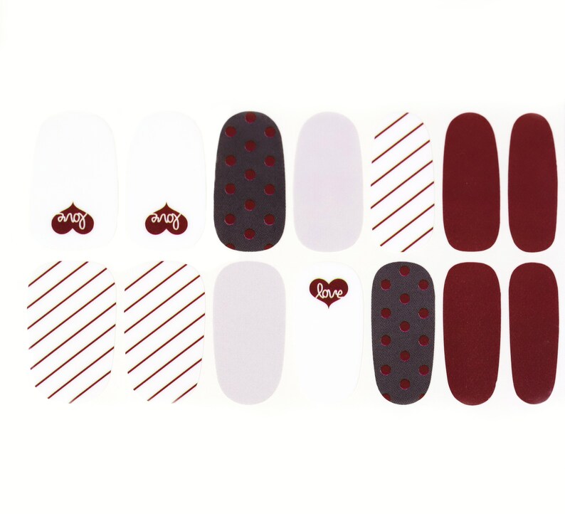 May include: Nail polish wraps with a variety of designs, including red and white stripes, polka dots, and solid red. The wraps also feature the words "love" and "you" in a heart shape.