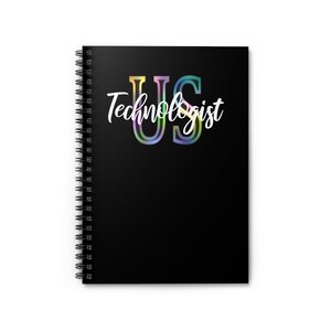 May include: Black spiral notebook with the text "US Technologist" in white with a rainbow gradient behind the letters.