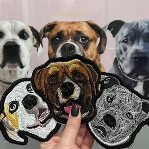 May include: Four embroidered dog patches, each featuring a different breed. The patches are brown, white, black, and gray. The patches are all about 4 inches in diameter.