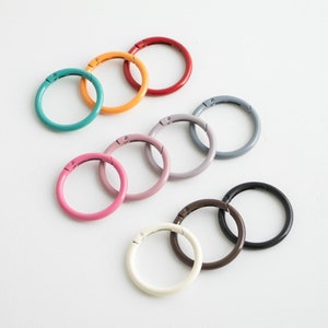 May include: Assortment of colorful metal key rings in various sizes. The key rings are made of metal and have a spring-loaded closure. The key rings are available in a variety of colors, including red, orange, yellow, green, blue, purple, and black.