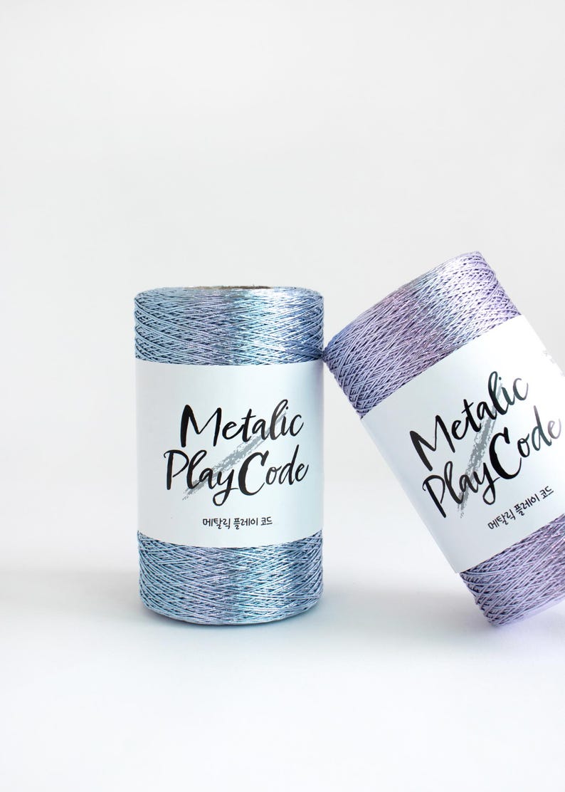 May include: Two spools of metallic thread, one blue and one purple, with the label "Metallic Play Code" and the text "메탈릭 플레이 코드" in Korean.