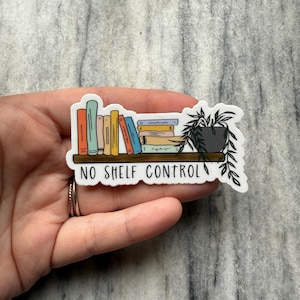 Może przedstawiać: Biała naklejka z ręcznie rysowanym obrazkiem regału pełnego kolorowych książek. Mała doniczka z rośliną znajduje się na górnej półce. Pod półką widnieje napis "NO SHELF CONTROL".