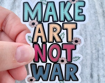 May include: A white sticker with the words "Make Art Not War" in colorful, outlined letters. The letters are decorated with small flowers and leaves.