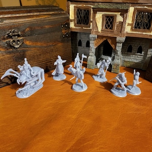 May include: A set of seven gray plastic miniature figures, including a spider with a rider, a knight with a sword, a wizard with a staff, and four warriors with swords and shields. The figures are arranged on a brown surface in front of a miniature building.