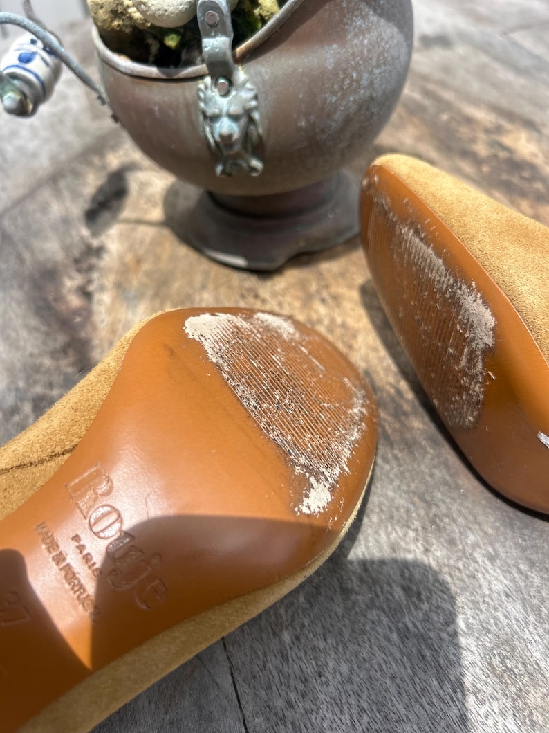 May include: A set of three ceramic mugs with a speckled, matte finish. The mugs are in shades of cream, light gray, and dark gray. Each mug has a simple, minimalist design and a rounded handle.
