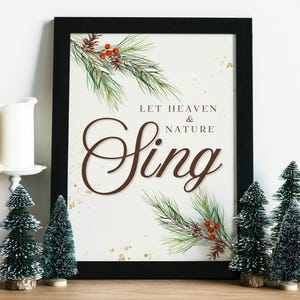 May include: A framed print with a white background and gold glitter. The print features a watercolor illustration of pine branches with red berries and the text "Let Heaven & Nature Sing".