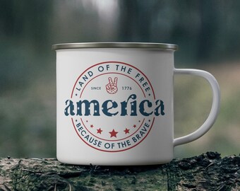 May include: White enamel camping mug with a red, white, and blue graphic that says "Land of the Free, Since 1776, America, Because of the Brave".