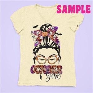 May include: A light yellow t-shirt with a graphic of a woman with a messy bun, wearing glasses and a bow with a skull and pumpkin pattern. The text "October Girl" is printed below the graphic.