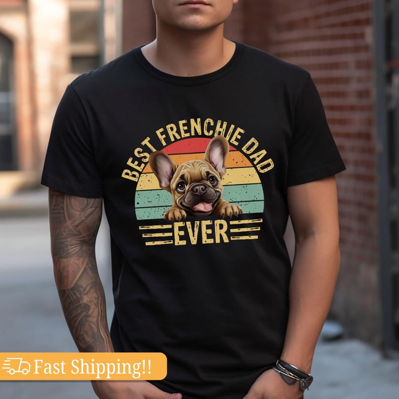 May include: Black t-shirt with a vintage-style graphic of a French Bulldog peeking over a sunset. The text reads "Best Frenchie Dad Ever".