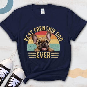 May include: Navy blue t-shirt with a vintage-style graphic of a French bulldog. The graphic says "Best Frenchie Dad Ever".