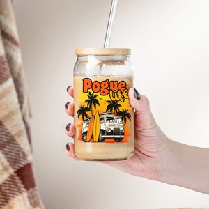 May include: A glass jar with a bamboo lid and a straw. The jar has a graphic of a van with surfboards and palm trees. The text "Pogue life" is printed on the jar.