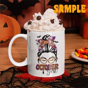 May include: White ceramic mug with a black and orange Halloween-themed design featuring a woman with a messy bun, glasses, and the text "October Girl".
