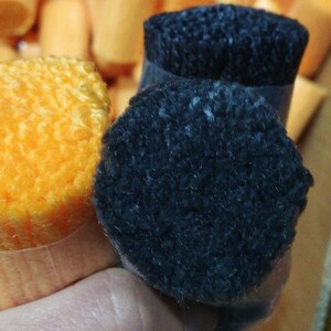 May include: Two spools of yarn, one orange and one black. The spools are wrapped in clear plastic.