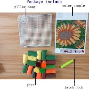 May include: A latch hook kit featuring a sunflower design. The kit contains a mesh canvas, yarn in a variety of colours, a latch hook tool, and a colour sample chart.