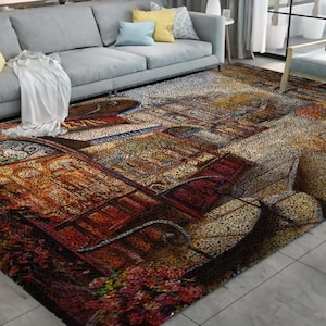 May include: A rectangular area rug with a detailed, colorful design. The rug features a pattern reminiscent of a European street scene, with warm tones of red, brown, and gold dominating the color palette. The rug is placed on a light gray floor.