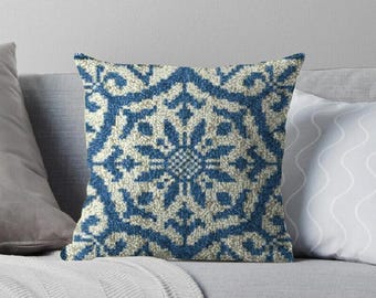 May include: Blue and white throw pillow with a geometric pattern. The pattern is a repeating design of a stylized flower.