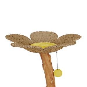 May include: A cat tree shaped like a flower with a brown wicker base and a yellow cushion. The tree has a natural wood trunk and a dangling yellow toy.