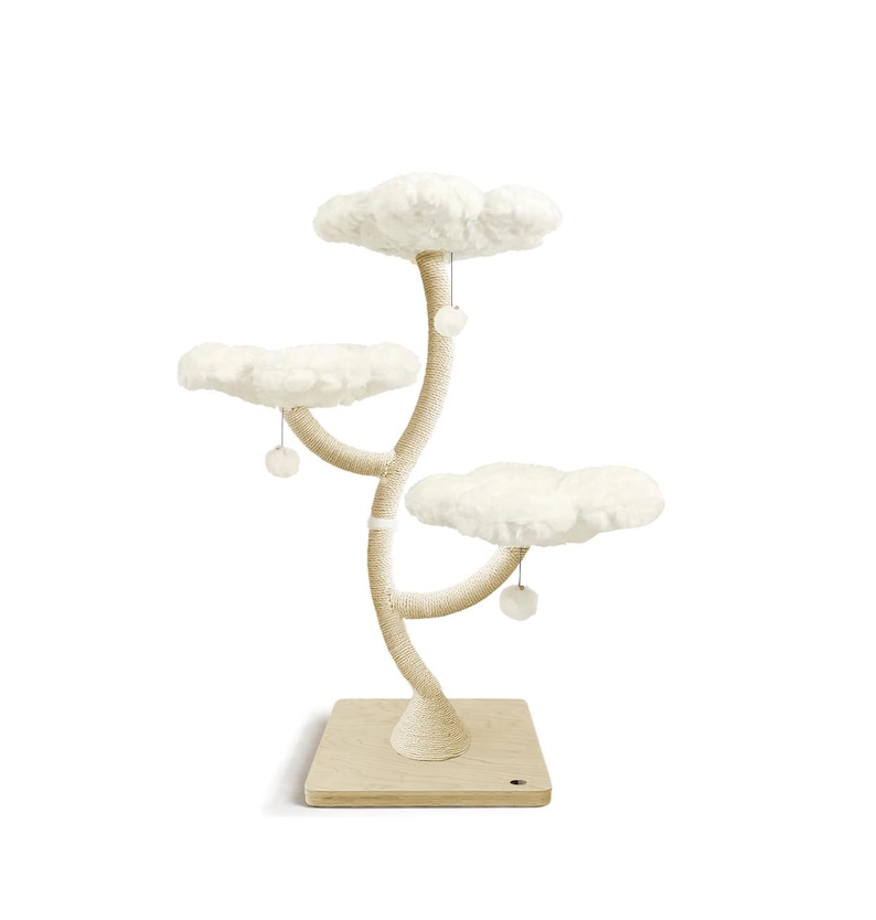 May include: A cat tree with three cloud-shaped platforms and a sisal-wrapped trunk. The platforms are covered in soft, white faux fur. The base is a light-colored wooden square. Small, white pom-poms hang from the platforms.