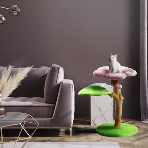 May include: A pink and green cat tree with a flower-shaped platform and a leaf-shaped platform. A white cat is sitting on the flower-shaped platform.