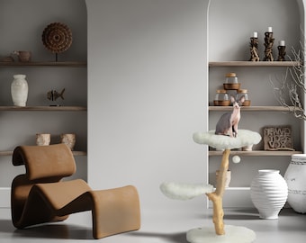 May include: A white cat tree with a fluffy white platform and a brown wooden trunk. The cat tree has three platforms and a hanging toy. A hairless cat is sitting on the top platform. The cat tree is in a room with a brown leather chair and shelves with decorative items.