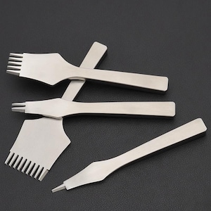 Op de afbeelding: Een verzameling roestvrijstalen leerbewerkingsgereedschappen, waaronder een multi-prong pons, een enkele prong pons en een groover. De gereedschappen zijn gerangschikt op een donkere ondergrond, waarbij hun scherpe randen worden getoond.