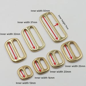 Op de afbeelding: Een verzameling goudkleurige metalen bandgleuven in verschillende maten. De binnenbreedtes vari&euml;ren van 13 mm tot 50 mm. De binnenhoogte van de grootste gleuf is 7 mm. Deze gleuven worden gebruikt voor het maken van tassen en andere ambachten.