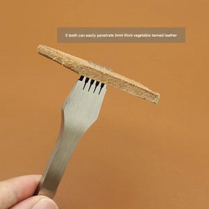 May include: A metal leathercraft tool with five prongs piercing a piece of tan leather. The text reads: "5 teeth can easily penetrate 5mm thick vegetable tanned leather."