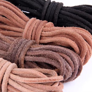 Peut inclure: Gros plan sur plusieurs faisceaux de cordons en cuir de différentes nuances de marron et de noir. Les cordons sont étroitement enroulés, mettant en valeur leur texture et leurs variations de couleur. L'image met en évidence l'aspect naturel et rustique du cuir.