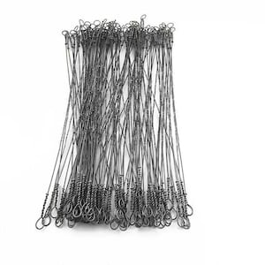 May include: A bundle of dark gray metal wire saw blades. Each blade has a looped end and a twisted section near the bottom. The blades are arranged in a loose, overlapping pattern against a white background.