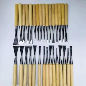 Peut inclure: Ensemble de ciseaux à bois avec manches en bois et lames en métal. Les ciseaux sont disposés en rangées, présentant diverses formes et tailles de lames. Les manches sont de couleur marron clair.