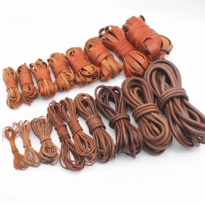 May include: Assortment of leather cords and laces in various shades of brown. The cords are bundled and tied, showcasing different thicknesses and textures. Ideal for crafting, jewelry making, or other DIY projects.