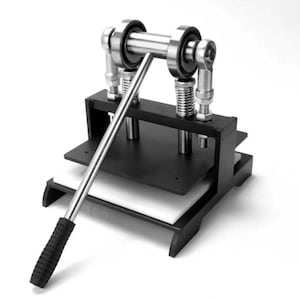 Puede incluir: Una máquina de corte manual para cuero con marco de metal negro, palanca de acero plateado con empuñadura texturizada negra, dos resortes verticales y una placa de presión plana. El dispositivo incluye una base blanca y rodamientos.